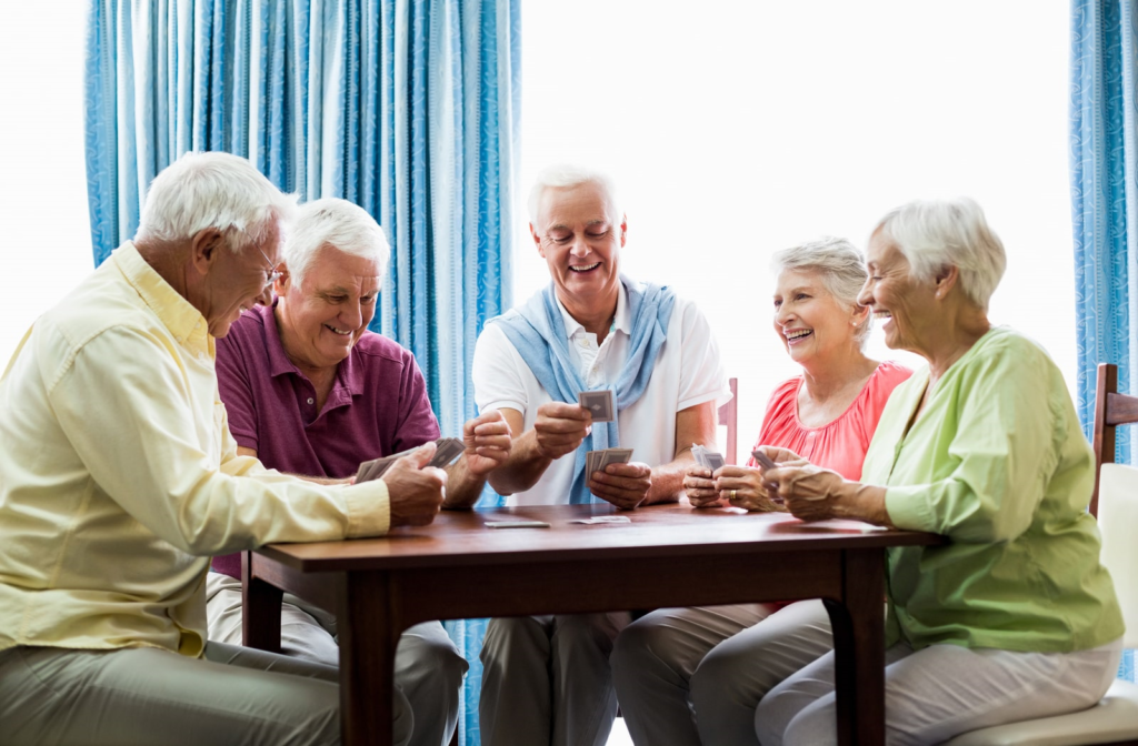 Elders playing cards together in senior home