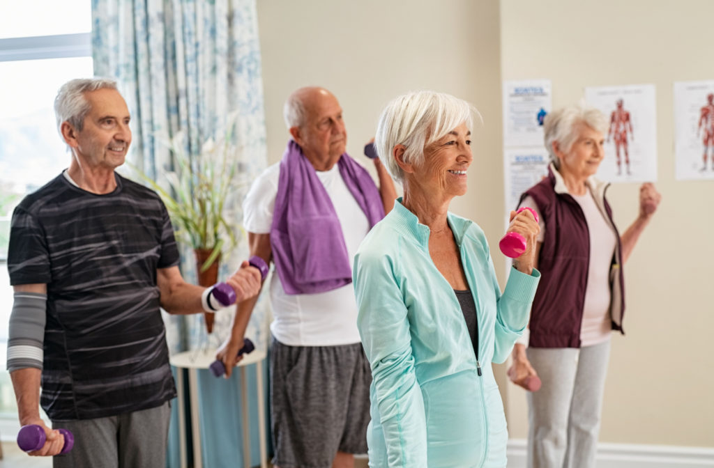 A group of seniors independently exercising at the gym in their assisted living community.