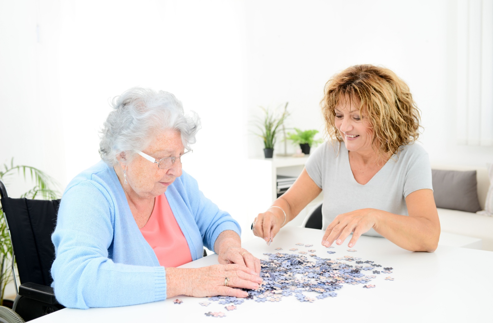 Mother and daughter enjoy putting together a jigsaw puzzle as a way to spend quality time.