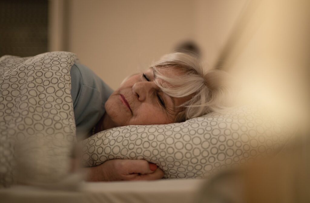 A senior sleeps peacefully in bed after establishing a bedtime routine in memory care to reduce instances of wandering.