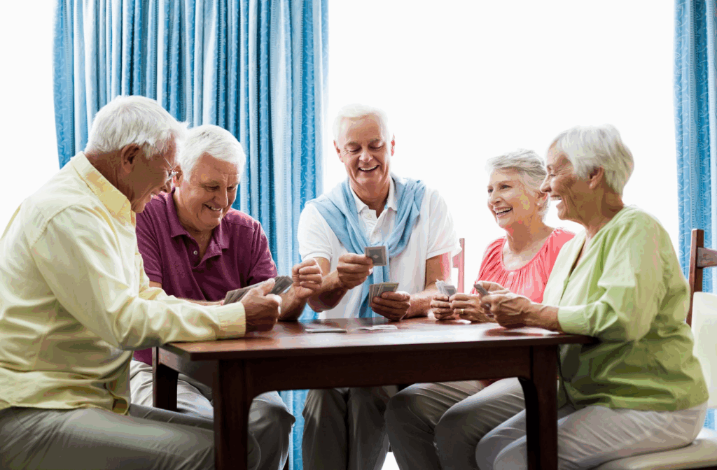 Elders playing cards together in senior home