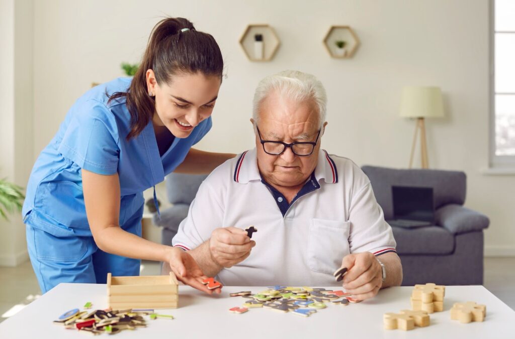 A smiling caregiver assists a senior as he plays letter matching game.