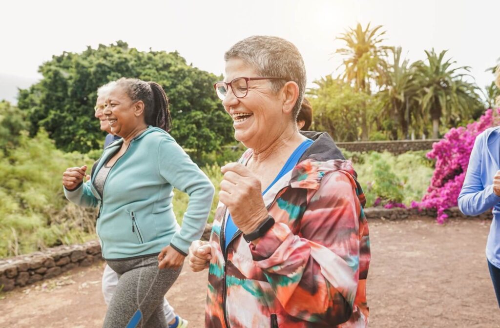 Smiling seniors walking together outdoors in athletic wear enjoying social wellness and exercise