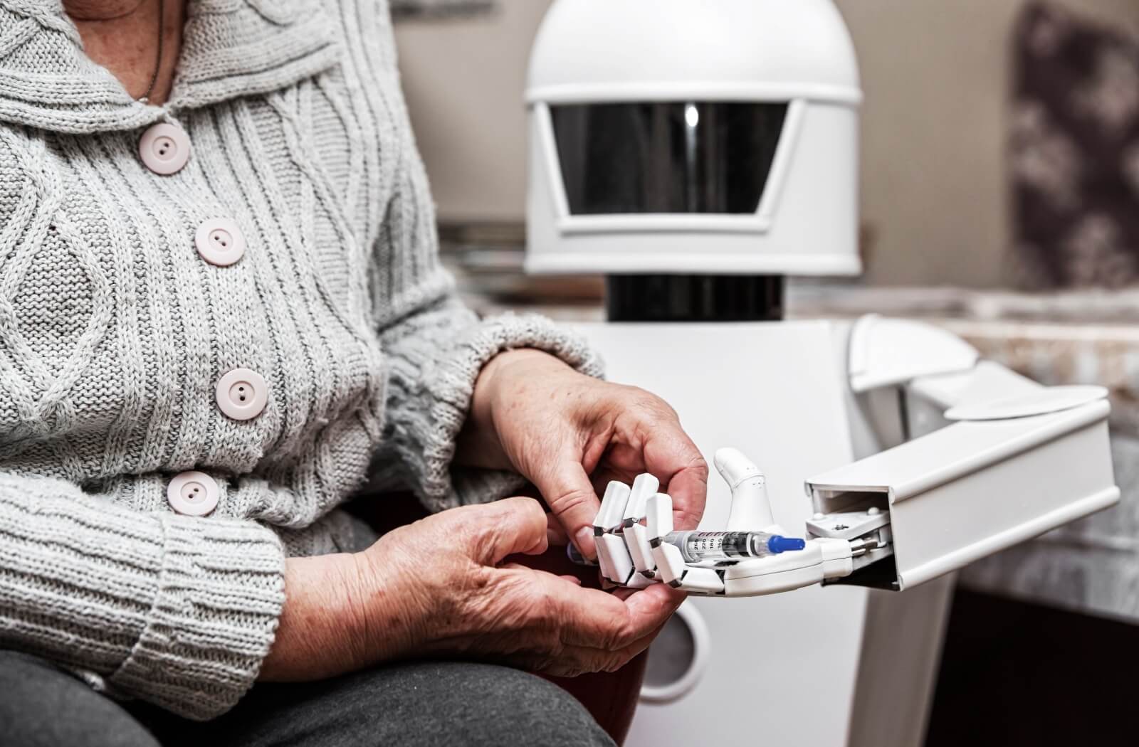 close up of a robot helping a senior giving her medication